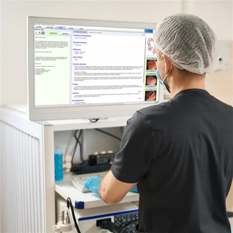 A medical professional standing at their endoscopy tower, accessing Argus® Intelligent Report Writer for a lower GI procedure.